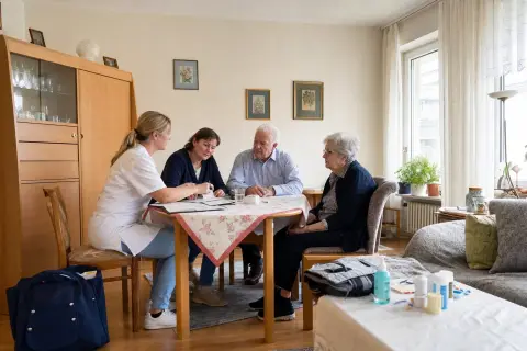 „Häusliche Krankenpflege – Voraussetzungen“: Eine Pflegefachperson bespricht mit einer pflegebedürftigen Person die weitere Versorgung nach einer Behandlung.