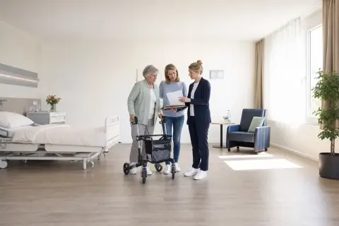 „Rehabilitation nach Krankenhaus – Unterlagen“: Eine Pflegefachperson bespricht mit einer pflegebedürftigen Person die weitere Versorgung nach einer Behandlung.